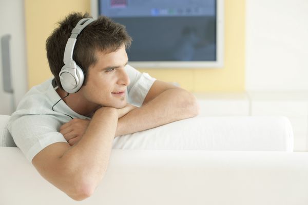 مرد جوان گوش دادن به موسیقی با هدفون در خانه