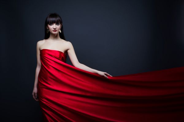 دختر زیبا در لباس قرمز بیش از پس زمینه سیاه و سفید