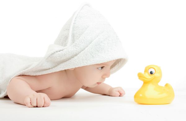 پرتره پسر بچه پیچیده شده در یک حوله با اردک حمام