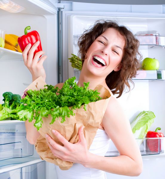 مفهوم رژیم غذایی دیابت زن جوان زیبا در کنار یخچال با غذای سالم میوه ها و سبزیجات