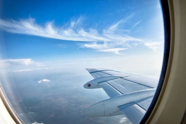 از طریق هواپیما پنجره در حین پرواز با یک آسمان آبی خوب نگاه کنید