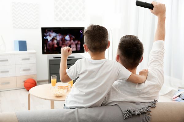 پدر و پسر تماشای تلویزیون در خانه مفهوم اوقات فراغت و سرگرمی