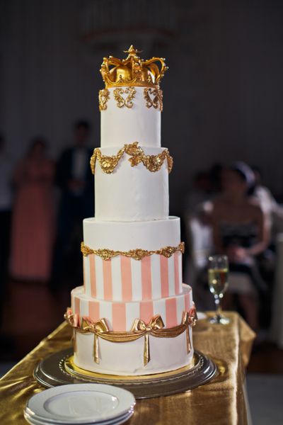 کیک عروسی خسته شده با تاج در بالا تزئین شده است