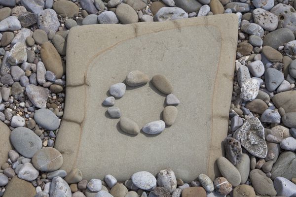 دایره دست ساخته شده از سنگ در قاب در ساحل
