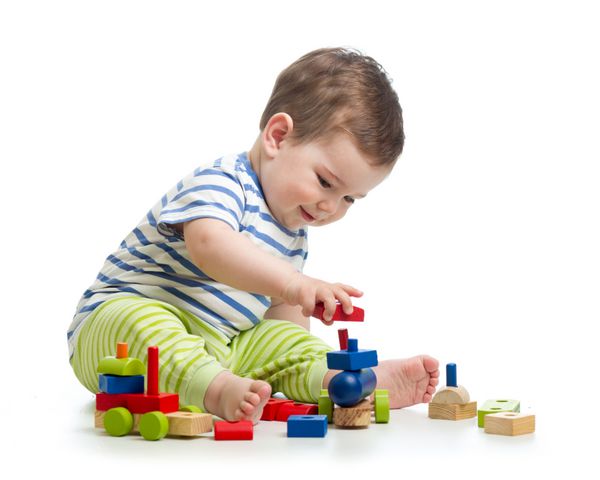 پسر بچه اسباب بازی با اسباب بازی های بلوک جدا شده بر روی زمینه سفید