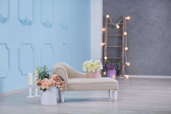 داخلی عکس را عکس می کند دیوار آبی با مبل چرم مبل و دیوار دیوان با گل و نردبان گیاهان تصویر پس زمینه با فضای کپی برای متن