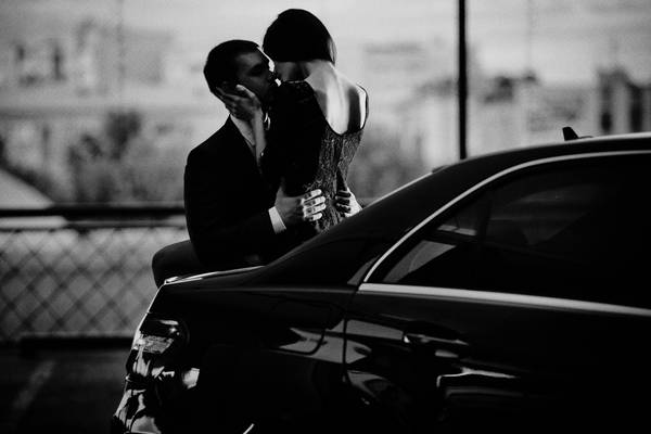 عکس سیاه و سفید از یک زن و شوهر بر روی تنه یک ماشین