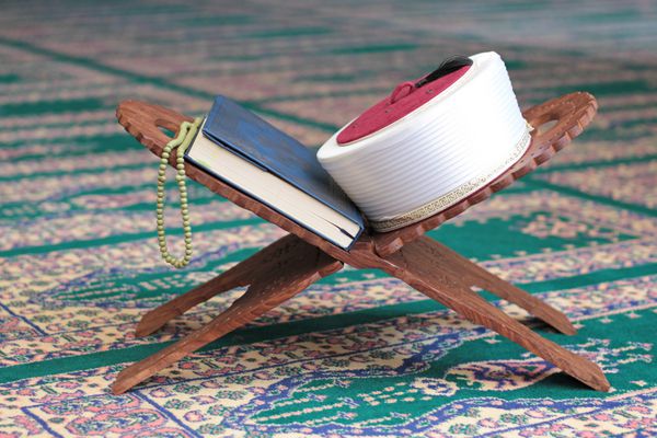 قرآن امام فهد و مهره های سبز در پایه چوبی در مسجد قرآن مذهب کتاب مقدس اسلام است