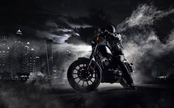 جزئیات هلی کوپتر موتور سیکلت با قدرت بالا با سوار مرد در شب شهر مدرن دبی و مه با نور پس زمینه در پس زمینه