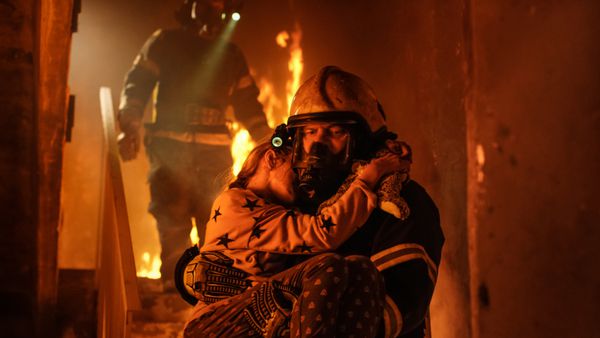 سوزاندن ساختمان گروهی از آتش نشانان بر روی پله های سوزان می افتند در ابتدا یک آتش نشان دختر را در آغوش او نگه داشته است