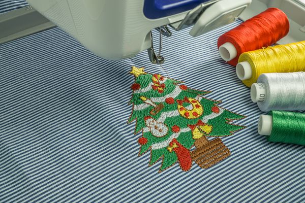 تصویری از ماشین لباسشویی فریز کار بستن درختچه کریسمس کوچک و چهار موضوع رنگی بر روی پارچه سفید و تار پارچه پنبه