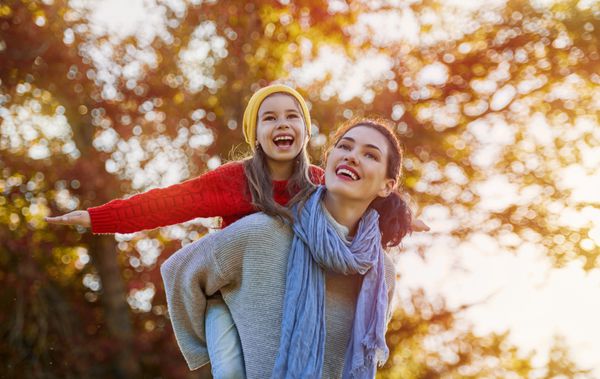 خانواده شاد در پاییز پیاده روی مادر و دختر راه رفتن در پارک و لذت بردن از طبیعت پاییز زیبا