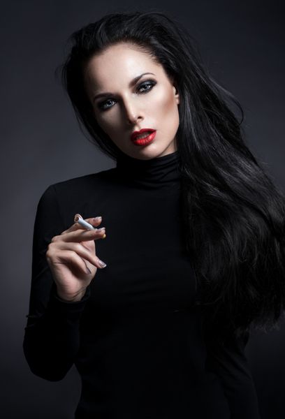 پرتره مرموز دختر جوان سیگاری در پس زمینه تاریک