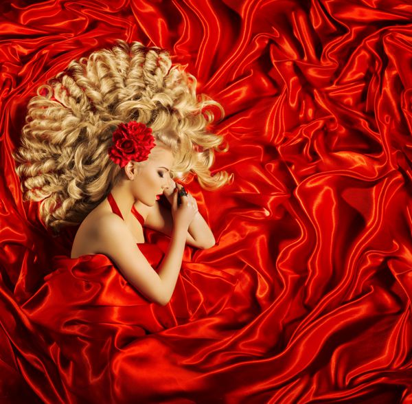 هنر زیبایی مو زن مدل موی زیبا و درخشان مدل لباس خواب بر روی پارچه ابریشمی قرمز
