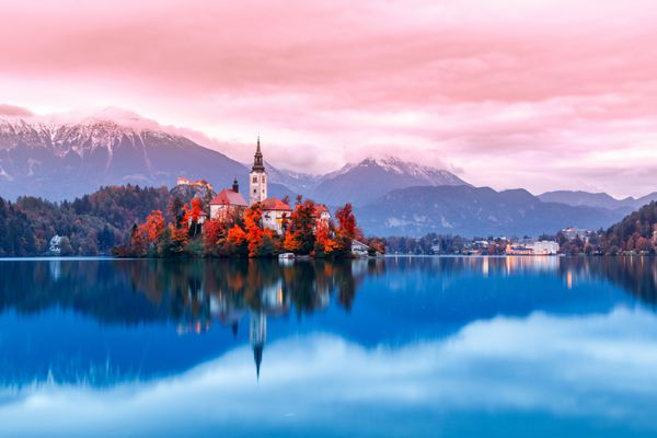 دریاچه بلد در اسلوونی نقطه عطفی معروف و بسیار محبوب و مقصد سفر است صحنه شبانه جزیره با کلیسای باستانی در وسط دریاچه بلد مکان رمانتیک مناظر غروب خورشید فصل پاییز