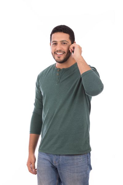 مرد خوش تیپ پوشیدن تی شرت سبز و شلوار جین مرد لبخند زدن و برقراری تماس جدا شده بر روی زمینه سفید