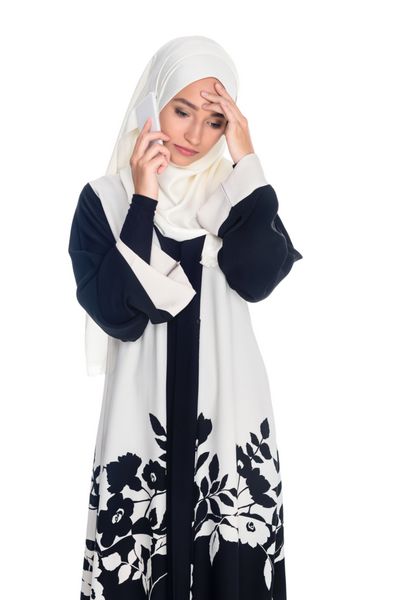 افسرده زن جوان مسلمان صحبت کردن با تلفن جدا شده در سفید