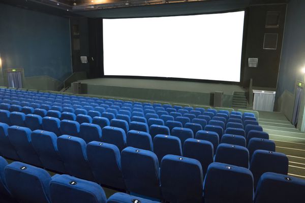 فیلم سینمایی خالی با ردیف صندلی های آبی و صفحه نمایش جدا شده سفید