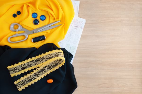 دوخت لباس براساس طرح دوخت لباس از پارچه ابریشم و تیفانی اسکلت قیچی دکمه حلقه موضوع برای لباس دوخت مورد نیاز است نمایش از بالا پارچه آبی و زرد