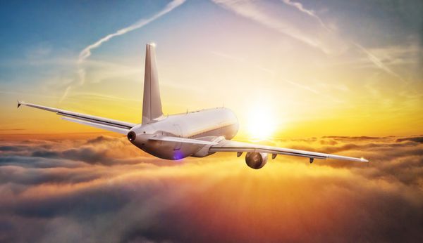 هواپیما تجاری پرواز در ابرهای بالاتر در نور غروب آفتاب وضوح بالا از تصویر مفهوم سریع مسافرت و حمل و نقل