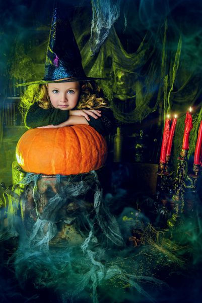 Happy Halloween Cute child girl in witch costume is in a witch