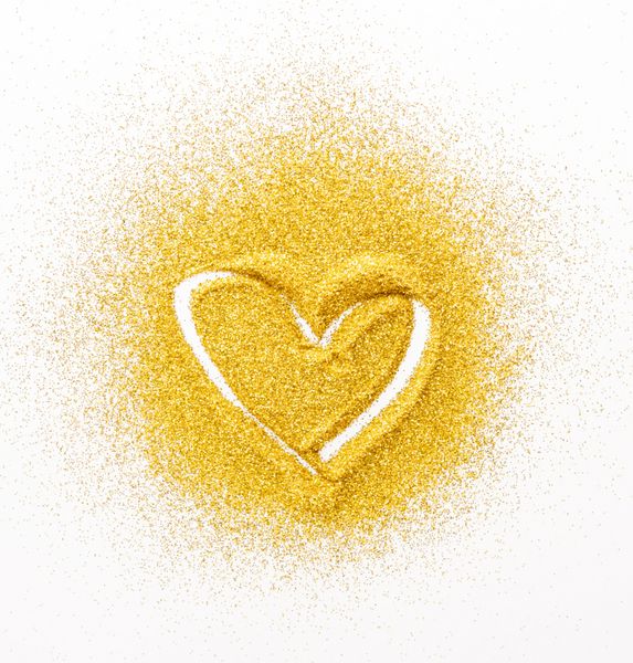 مفهوم نقاشی شن و ماسه بافت زرد طلایی بر روی سطح سفید با شکل قلب پس زمینه انتزاعی نمای بالا گسترش یافته است دکوراسیون گلوله زرد گردنبند کارت دست ساز با فضای کپی