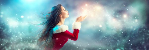 دختر مد لباس کریسمس زمستان دمیدن سحر و جادو برف در دست او پری سال نو زیبا و درخت کریسمس مدل موهای تعطیلات آرایش هدیه زیبایی مدل زن در تعطیلات سایه آبی رنگ آبی فروش