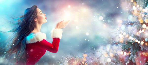 دختر مد لباس کریسمس زمستان دمیدن سحر و جادو برف در دست او پری سال نو زیبا و درخت کریسمس مدل موهای تعطیلات آرایش هدیه زیبایی مدل زن در تعطیلات سایه آبی رنگ آبی فروش