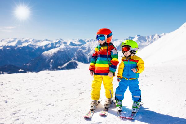 اسکی کودکان در کوه بچه در مدرسه اسکی ورزش زمستانی برای بچه ها تعطیلات خانوادگی کریسمس در آلپ کودکان اسکی روی زمین را یاد می گیرند درس اسکی آلپ برای پسر و دختر لذت برف در فضای باز