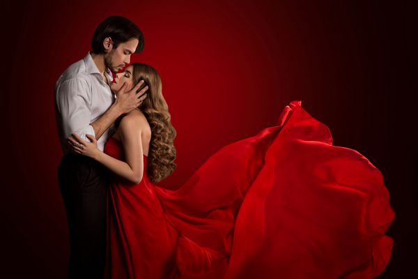بوسیدن زن و شوهر زن جوان بوسه زن زیبا لباس قرمز لباس فرش مفهوم عشق عاشقانه