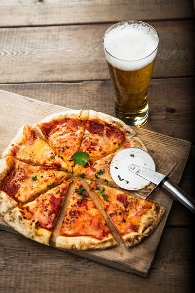 پیتزا و دلستر روی میز چوبی