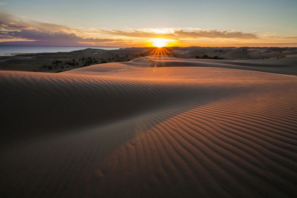 منظره صحرا چشم انداز با غروب آفتاب طلایی بیش از تپه های شنی