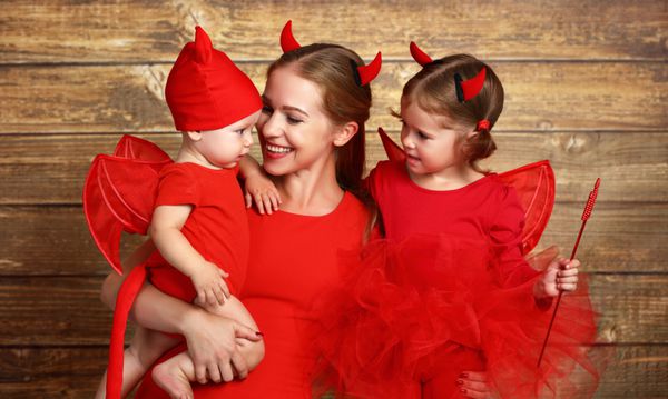 خانواده شاد با لباس شیطان برای هالووین آماده می شود
