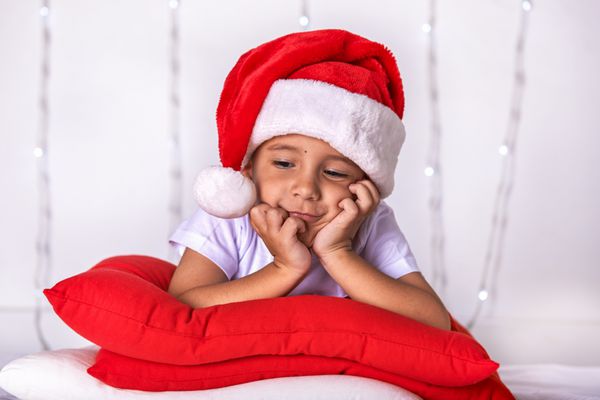 یک کودک کوچک به عنوان سانتا کلاوس در انتظار کریسمس و سال نو