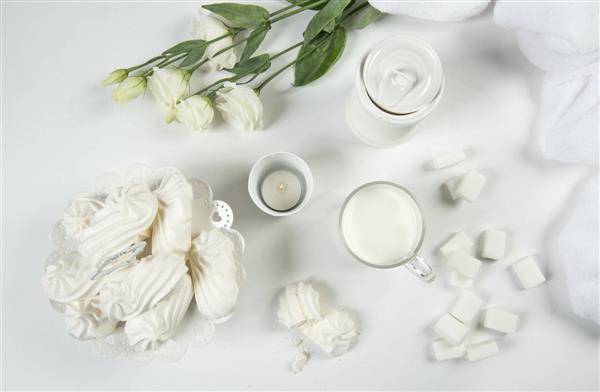 دسرهای خوشمزه با رزهای سفید روی میز عروسی