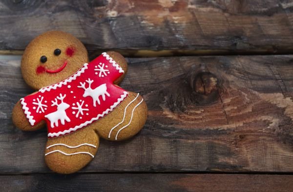 لبخند زدن کریسمس مردان شیرینی زنجفی بر روی زمینه های چوبی