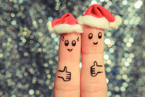 هنر انگشت از زن و شوهر جشن کریسمس مفهوم مرد و زن خنده در کلاه سال جدید مبارک مبارک نشان دادن شگفت انگیز تصویر تونر
