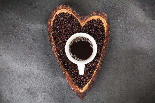 دانه های قهوه در یک کاسه قلب شکل
