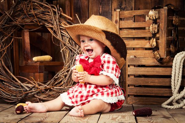 کودک دختر شاد که در سبک کشور لباس پوشید