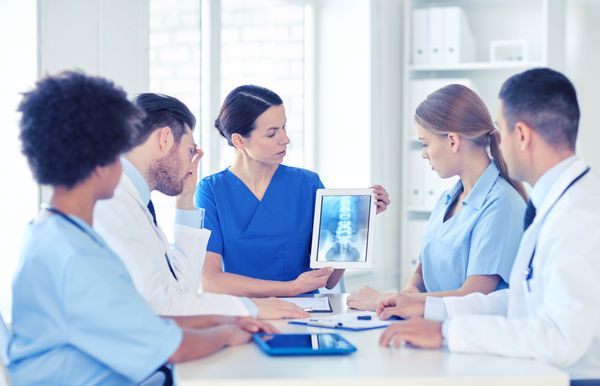 گروه پزشکان با اشعه ایکس روی کامپیوتر قرص در کلینیک