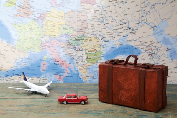 سفر یا سفر با مفهوم هواپیما هواپیمای اسباب بازی مینیاتوری و چمدان بر روی نقشه