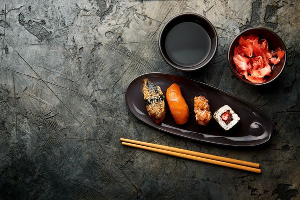 تغییر سوشی و رول روی میز سنگی رول سوشی sashimi با chopsticks تنظیم شده است نمایش بالا با فضای کپی
