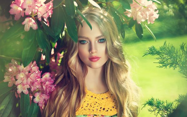 دختر مدل بهار زیبا در گل در تابستان شکوفه پارک زن در یک باغ شکوفه مد آرایشی و بهداشتی