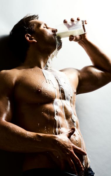 مرد ورزش کار خوش تیپ و عضلانی در حال نوشیدن آب