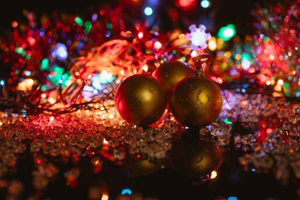 تزئینات کریسمس بر روی سیاه و سفید توپ شیشه ای و چراغ