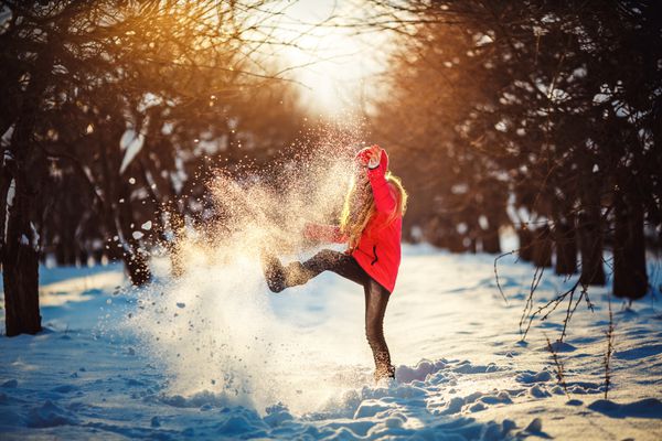 پرتره از دختر زیبا پرتاب برف در چوب زمستان