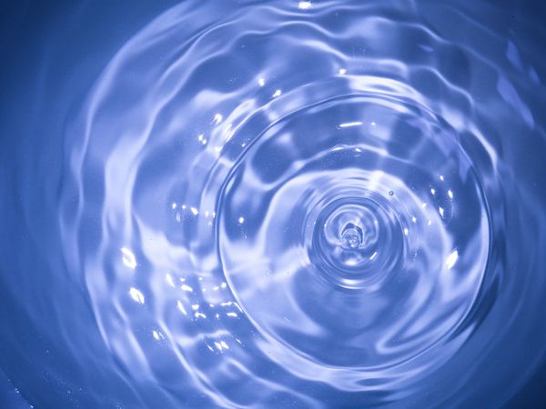 دیدگاه بالا حلقه آب آبی نزدیک آب پاک قطرات آب نزدیک به سطح تاثیر می گذارد تشکیل حلقه ها روی سطح بازتاب در آب آبی