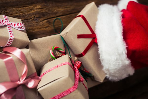 کارت های کریسمس و هدایای با کلاه سانتا در زمینه های چوبی w