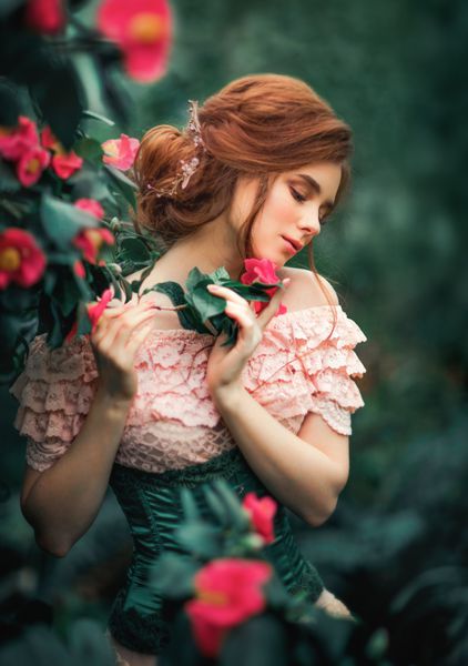 یک عکس زیبا از یک دختر موهای قرمز زیبا را در یک لباس پرنعمت صورتی که در نزدیکی گل های رنگارنگ قرار دارد بست کار هنری زن رمانتیک مدل آرامش گرایی