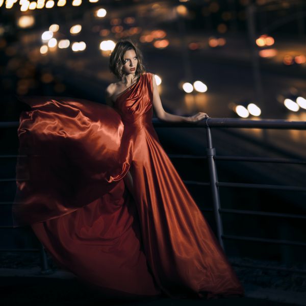 زن زیبایی جوان در لباس قرمز لرزان
